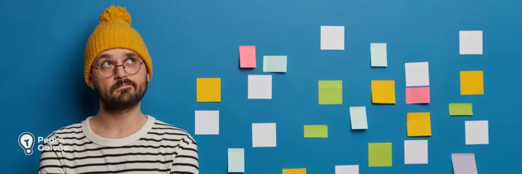 Pessoa com vários post-its colados na parede ao lado para indicar estudo de tempos verbais em inglês