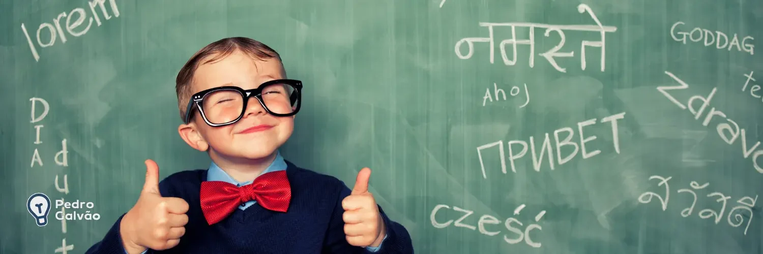 Criança com óculos dando um sorriso e fazendo joinha com uma lousa atrás com vários idiomas escritos para indicar os idiomas mais falados do mundo