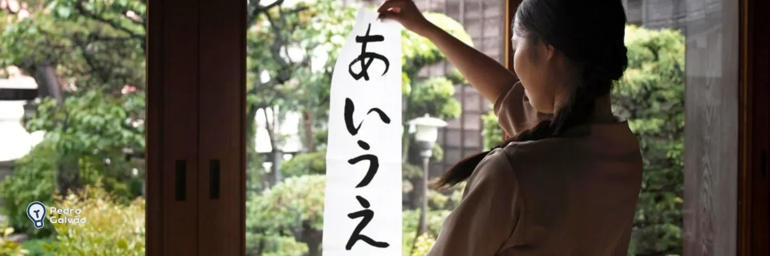 Mulher segurando uma folha grande com as vogais do japonês em hiragana para indicar partículas japonesas